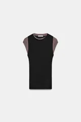 Top de manga caída, con efecto de doble capa. La capa exterior es negra y ajustada, mientras que la capa interior, visible en mangas y cuello, es de color marrón topo.