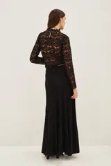 Falda larga de punto en color negro, con diseño plisado y acabado con sutil brillo metalizado. Presenta un corte acampanado con caída fluida.