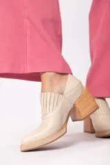 Zapato de cuero color beige con punta fina y taco de madera.