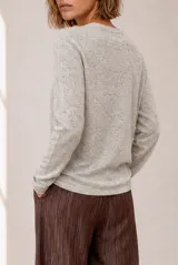 Sweater tejido de punto melange color bordó, con escote en V y mangas largas.