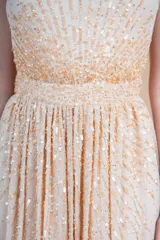 Vestido largo de fiesta color durazno, confeccionado en gasa bordada con lentejuelas al tono.