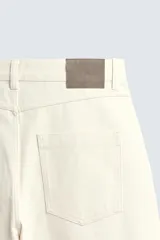 Pantalón relaxed fit negro confeccionado en tejido de algodón con estructura diagonal, estilo de cinco bolsillos y cierre frontal con cremallera y botón metálico.