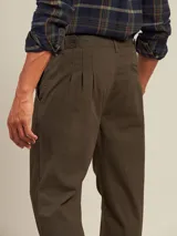 Pantalón de vestir color beige con pinzas, bolsillos laterales y traseros. El ruedo tiene un pequeño corte lateral.