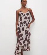 Vestido largo de corte evasé confeccionado en chiffon con estampado animal print. Presenta escote en V, breteles finos ajustables y diseño sin mangas. Incorpora una capa adicional en el ruedo que aporta movimiento y fluidez a la prenda.