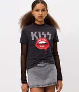Remera baby tee de algodón color negro, con cuello redondo y mangas cortas. Presenta una estampa frontal con el logo de la banda KISS en pedrería brillante y un gráfico de labios rojos en el centro.