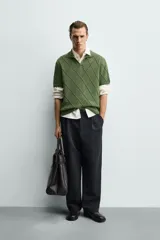 Polo regular fit verde de punto de algodón, con cuello solapa, abertura frontal y diseño de calados geométricos en rombos.