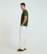 Remera verde militar de algodón texturizado, corte regular, cuello redondo y mangas cortas. Estampa tropical de una casa y palmeras en el pecho.