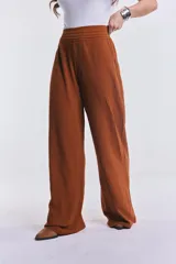 Pantalón camel de pierna ancha y corte recto, con pretina elástica fruncida en la cintura.