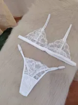 Conjunto de lencería compuesto por un bralette triangular de encaje floral con breteles regulables y una bombacha tipo tanga de encaje a juego con laterales ajustables.