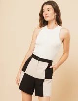 Short de lino color beige y naranja, de tiro alto con elástico en la pretina trasera, cierre delantero y botón, bolsillos delanteros y dobladillo invisible.