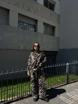 Conjunto de dos piezas compuesto por un sweater de manga larga y pantalón de corte recto, ambos con estampado abstracto en tonos marrón, negro y blanco.
