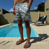 Short de baño negro con estampado de rodajas de naranja, cintura elástica con cordón ajustable y logo circular en el ruedo.