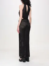 Vestido largo negro calado de malla con lunares brillantes, cuello halter, cortes en los laterales, aberturas laterales y forro.