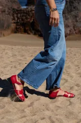 Sandalias de cuero color marrón con tiras entrecruzadas, hebilla lateral y taco cuadrado de madera.