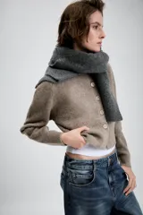 Chaqueta de punto suave en color beige melange, con cuello redondo, manga larga y cierre frontal de botones.