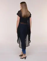 Blusa larga negra de gasa liviana con silueta amplia y desestructurada, escote redondo, mangas cortas caídas y bajo asimétrico más largo en la parte posterior.