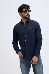 Camisa de manga larga de lino y algodón color azul marino, de corte semi slim, con cuello camisero y cierre frontal de botones blancos. Presenta un pequeño logo bordado en el pecho.