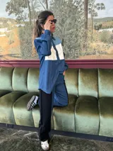 Pantalón de tiro alto con pierna ancha, confeccionado en denim azul y cuerina negra.