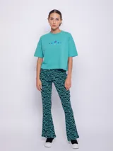 Remera corta color aguamarina con cuello redondo y mangas cortas. Presenta un bordado de flores azules en el frente.