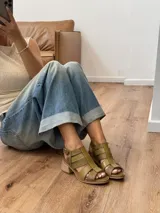 Sandalias de cuero color marrón con tiras anchas y hebilla lateral.