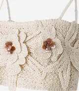 Blusa cropped color crudo, tejida a crochet, con breteles finos y apliques de flores con centro marrón.