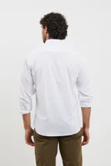 Camisa azul de algodón con elastano, cuello button-down y manga larga.