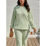 Conjunto de pijama de dos piezas confeccionado en plush suave con textura de ochos. Incluye una remera de manga larga con cuello redondo y un pantalón de corte recto con cintura elástica.