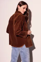 Sobrecamisa de pana color rojo, con cierre frontal de botones, bolsillos delanteros con solapa y ruedo desflecado.