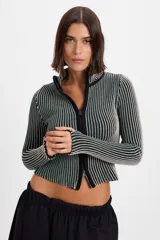 Campera corta de tejido de punto acanalado con diseño de rayas verticales en dos tonos. Presenta cuello alto y cierre frontal completo con borde en color negro.