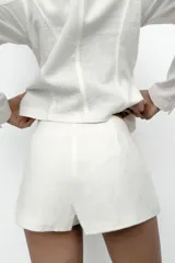 Shorts de tiro alto confeccionados en mezcla de ramio, de color blanco. Presentan forro interior a tono y diseño con doble botonadura frontal.