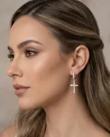 Caravanas de plata 925 con diseño de cruz colgante, adornadas con circonias brillantes. Cuentan con un cierre tipo pasante clip.
