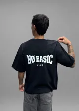 Remera boxy negra de manga corta, con cuello redondo y diseño amplio en hombros y cuerpo. Cuenta con un pequeño estampado frontal en blanco en el pecho con la inscripción "NØBASIC CLUB".