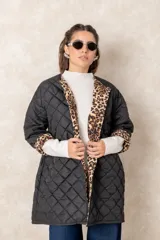 Campera acolchada de corte recto y largo medio, color negro con diseño capitoneado. Presenta un interior con estampado animal print que se destaca al remangar las mangas.