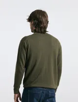 Polera de tejido de punto fino en color verde oliva, con cuello alto acanalado y mangas largas.