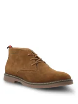 Botas tipo chukka Hush Puppies modelo New Safari, confeccionadas en descarne color marrón tostado. Presentan cordones al tono, costuras reforzadas en la suela y detalle de etiqueta con franjas en el talón.