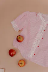 Blusa de algodón a rayas rosadas y blancas, con mangas cortas abullonadas, cuello mao y detalles de tela estampada floral en la botonera y los puños.