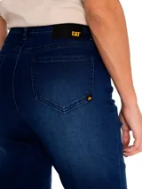 Jeans de corte ajustado en color azul índigo, con diseño clásico de cinco bolsillos, cierre de cremallera y botón metálico, y parche de marca en la parte trasera.