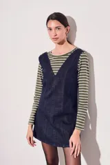 Vestido jumper corto de jean azul oscuro, con escote en V y breteles anchos.