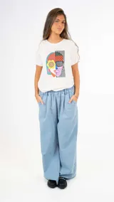 Remera blanca de algodón con estampado abstracto de rostro en colores.