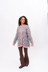 Saco de punto con diseño de bloques geométricos en tonos celeste y marrón, con cuello redondo, cierre frontal de botones y terminaciones en color rosado.