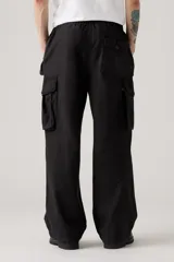 Pantalón cargo negro de corte holgado, con cintura elástica y cordón ajustable. Presenta bolsillos laterales y bolsillos cargo con solapa en los muslos.