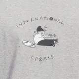 Remera gris jaspeado de Adidas con estampado de un personaje sentado en una patineta con el texto "International Sports".