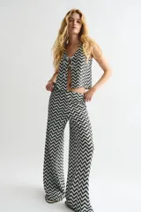 Pantalón de tiro alto confeccionado en punto jacquard con diseño de zigzag en blanco y negro. Presenta un corte de pierna amplia y cintura elástica.