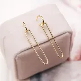 Aros colgantes dorados con forma rectangular.