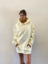 Hoodie oversize color crema, con capucha ajustable mediante cordones y bolsillo frontal tipo canguro. Presenta un diseño estampado de un león en la espalda.