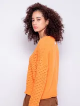 Sweater de tejido de punto color naranja, con diseño de calados, manga larga y cuello redondo.
