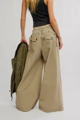 Pantalón chino de tiro bajo, color negro, pierna muy ancha, con cintura elástica con cordón ajustable y pinzas en la parte superior.