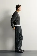 Jersey regular fit de punto ligero color gris oscuro, tejido en hilatura de lana con cuello en V, manga larga y acabados en rib.