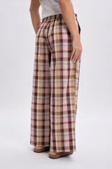 Pantalón de corte ancho a cuadros en tonos de verde, marrón y rosado.