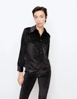 Camisa de punto negro con diseño de rayas diagonales en hilo metálico de lurex, corte slim, cuello camisero clásico y cierre frontal abotonado.
